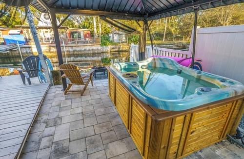 Weeki Wachee Gardens House | River home with huge arcade, hot tub kayaks, mini golf and floating pad, 80in TV