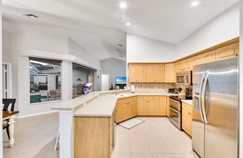 Central Naples House | This 3/2 home enjoys a Southwest facing lakefront view with pool and spa