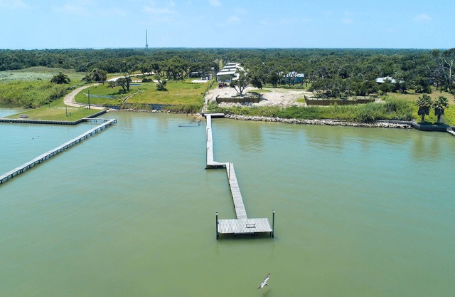 3 bedroom 2 bath nestled in the oak trees right on Copano Bay! Private Pier!